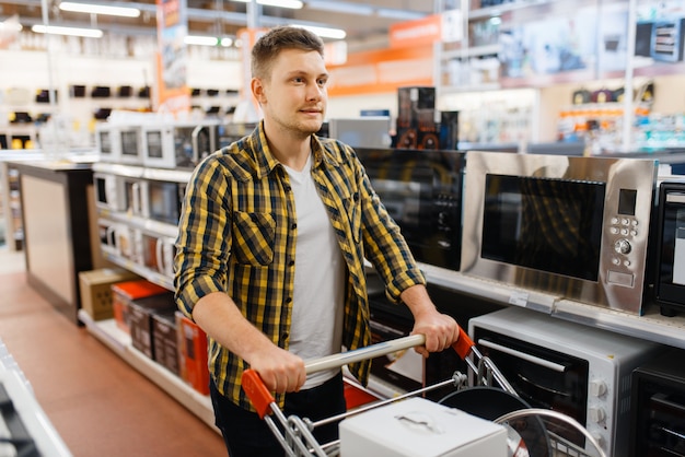 Фото Человек, выбирающий микроволновую печь в магазине электроники