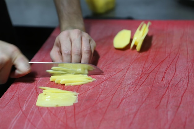 L'uomo trita le patate per cucinare.