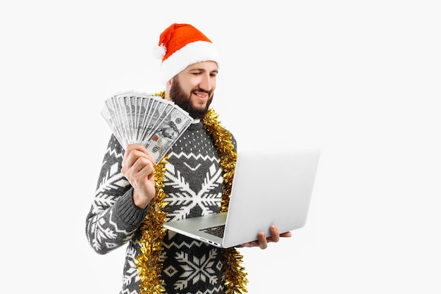 A man in a Christmas hat and a laptop a man holding dollars