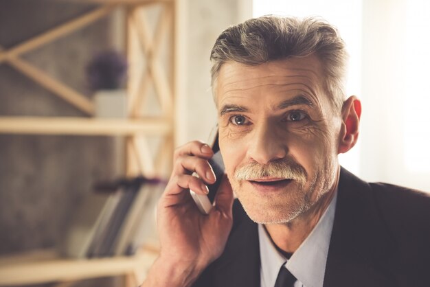 Photo man in classic clothes is talking on the mobile phone