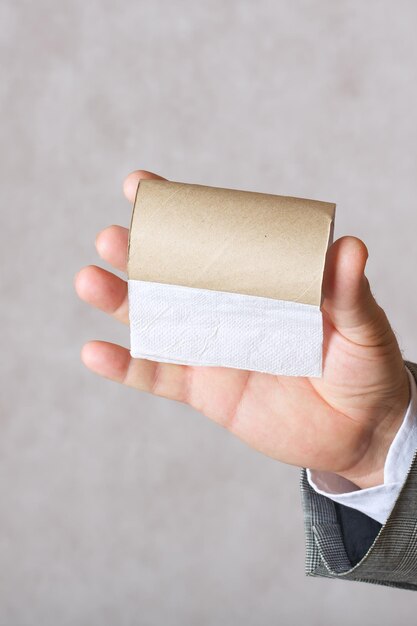 A man in a classical costume keeps a finished toilet paper roll. Closeup. Free space for a text.