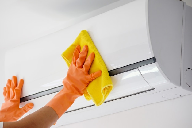 Man cleaning air conditioner with microfiber cloth