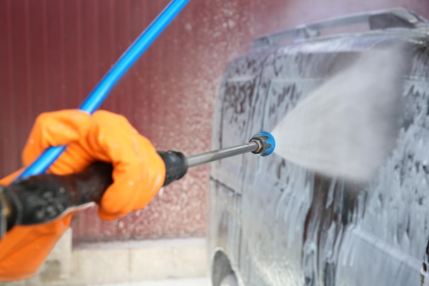 Man cleaning car with high pressure water