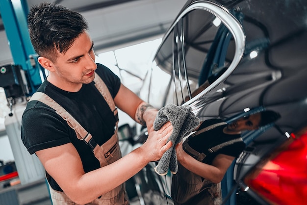 A man cleaning car with a microfiber cloth car detailing concept Close up view