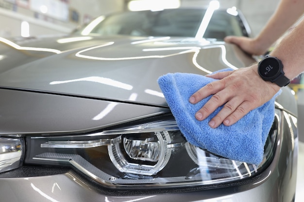 Man cleaning a car with microfiber cloth car wash services concept