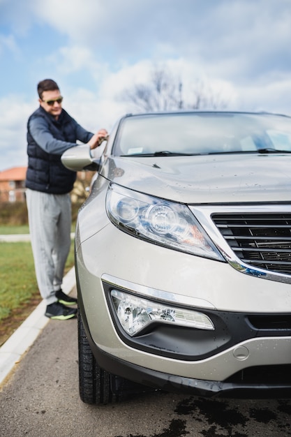 A man cleaning car with microfiber cloth