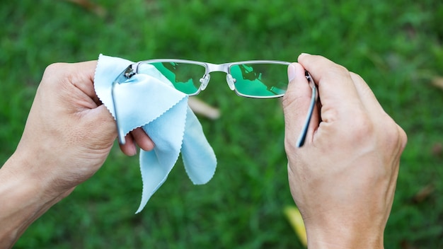 Man cleaning the glasses with microfiber fabric.