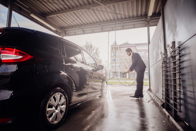 洗車で車を掃除する男。