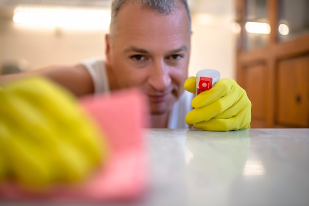 Man cleaning home with protective gloves