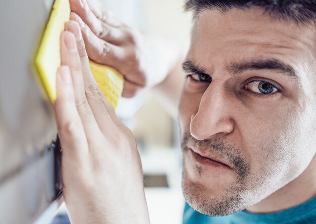 Man cleaning kitchen furniture