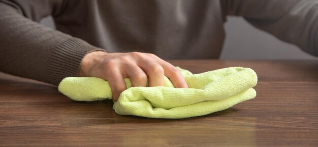 Man cleaning table using rag at home