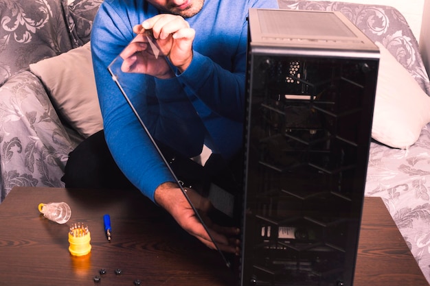 the man cleans the dusty computer