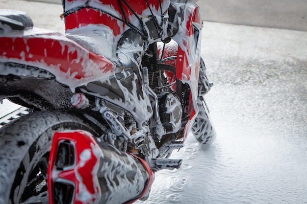 Man cleans a motorcycle in the wash