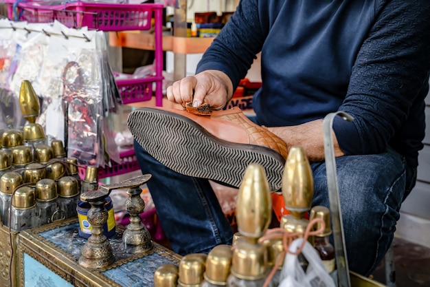 Man cleans shoes with help of shoe polish on street, ancient method of shoe cleaning