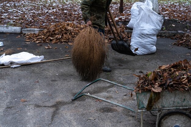 A man cleans and sweeps a yard