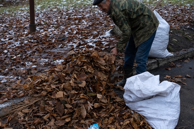 A man cleans and sweeps a yard