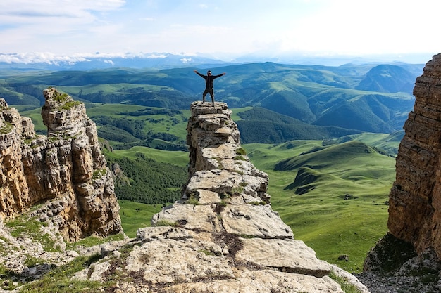 A man on the cliff of the plateau against the background of Mount Elbrus Bermamyt