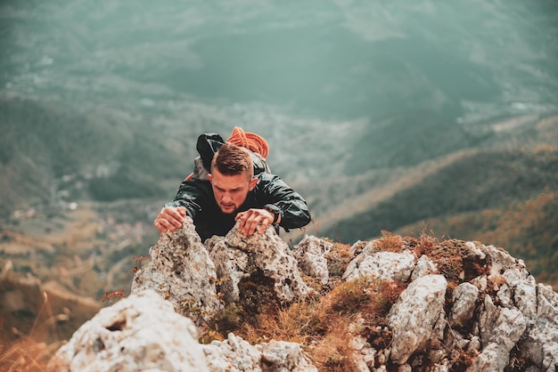 Man climbing on the rock mountain cliff adventure extreme sport\
outdoor adrenaline challenge