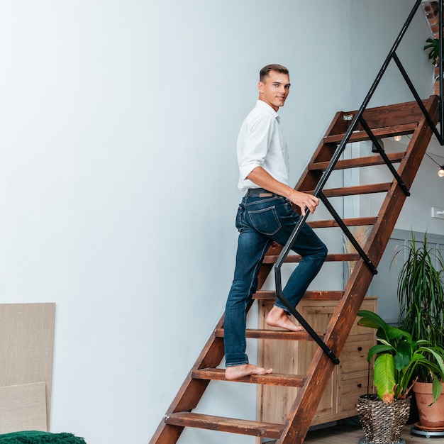 Photo man climbing the stairs in his apartment