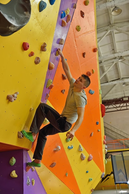 Photo man climbing up on practice wall
