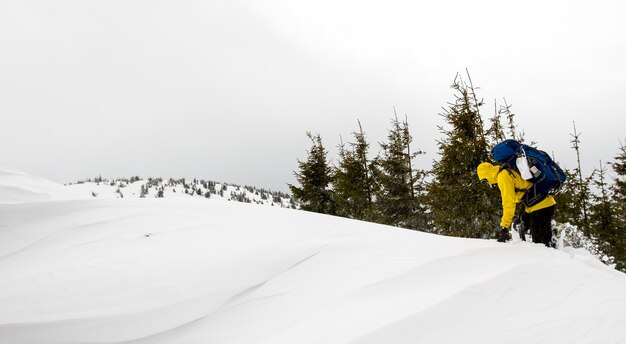 Foto l'uomo sale in cima con un grande zaino pesante