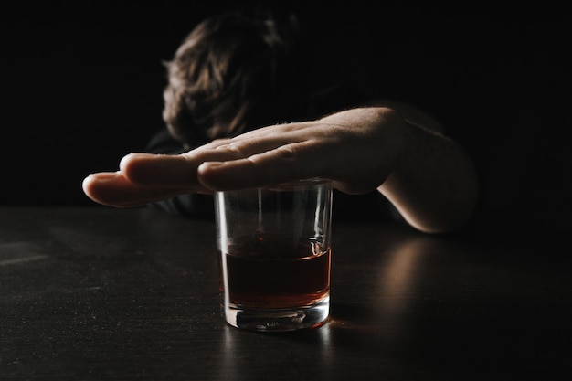 Man close glass lying or sleeping on table at night Alcohol addiction concept