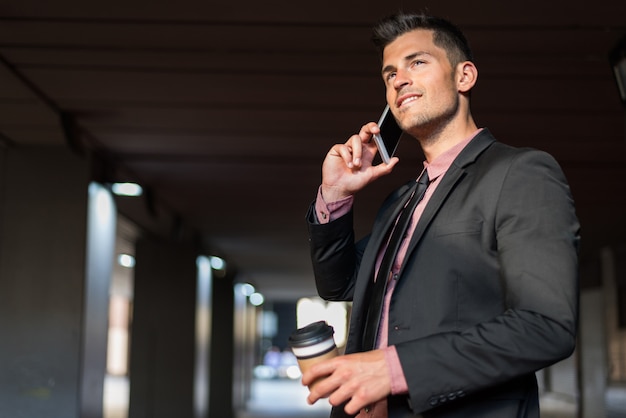 Man close up with a mobile phone and coffee