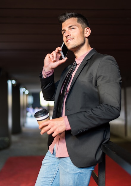 Foto uomo vicino con un telefono cellulare e un caffè