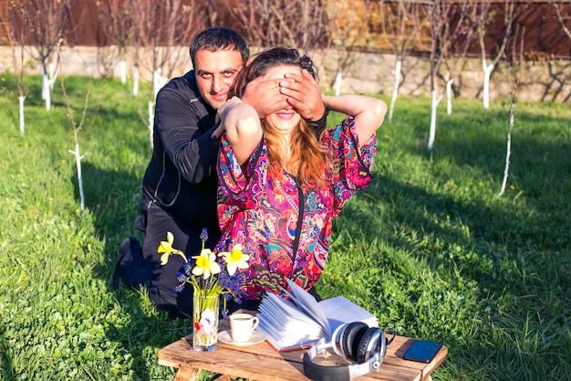 Мужчина закрыл глаза женщины для рук в саду