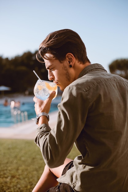 Man cocktail drinken bij het zwembad - lente en zomer