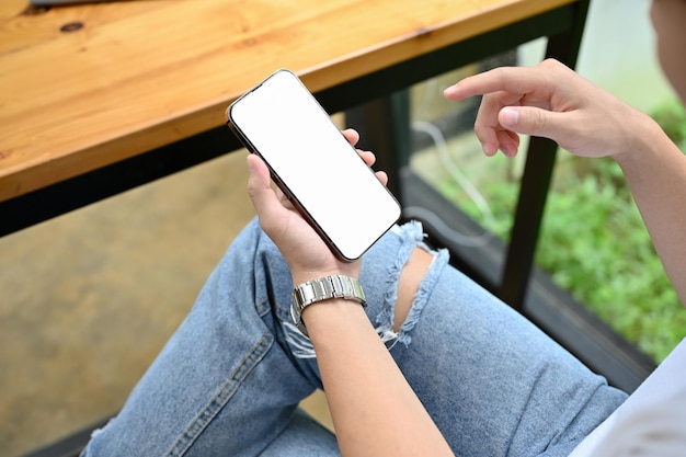 A man in the coffee shop using his smartphone phone white screen mockup closeup