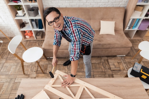 A man collects furniture at home and looks up.