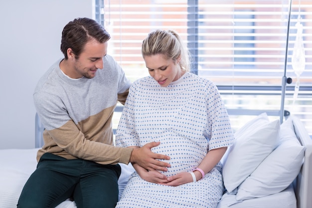 Man comforting pregnant woman in ward