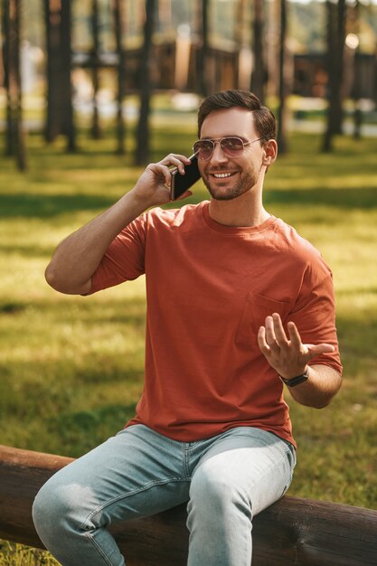 自然の中でスマートフォンで通信する男