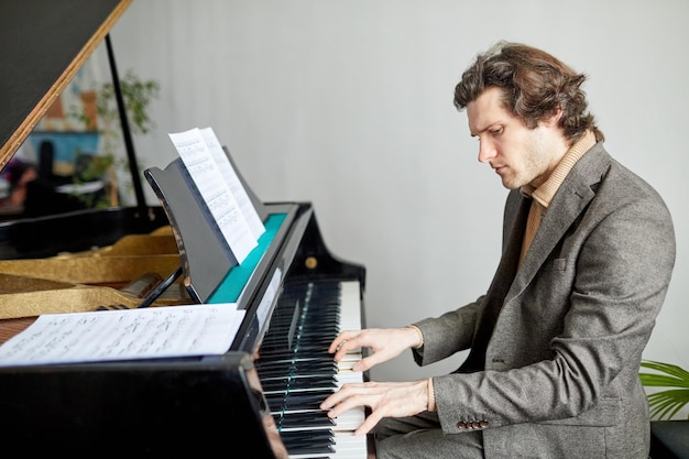 Man composing the music on piano