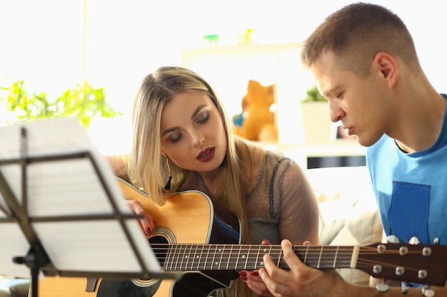 Photo man conducts guitar lessons for woman closeup