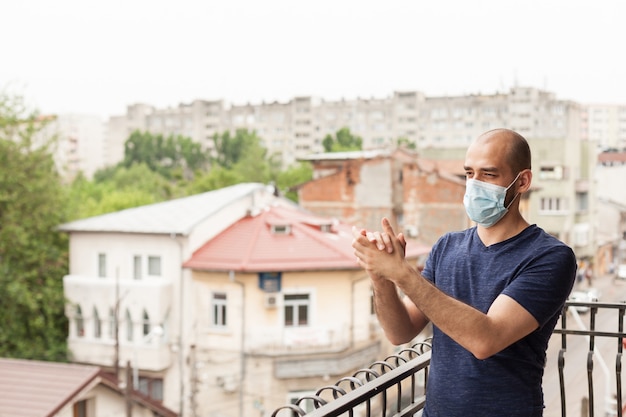 L'uomo si congratula con il personale medico che applaude dal balcone del suo appartamento.