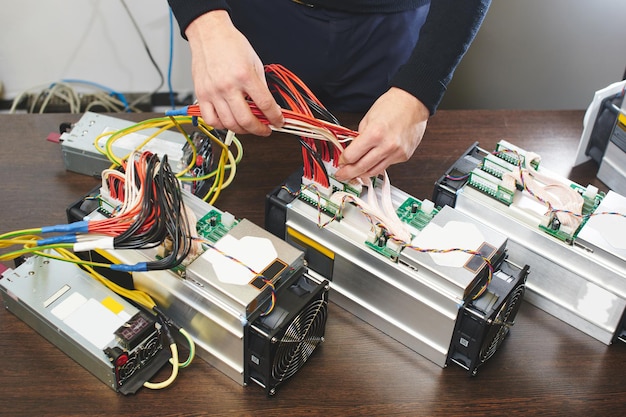 A man connects the equipment for mining cryptocurrency bitcoin