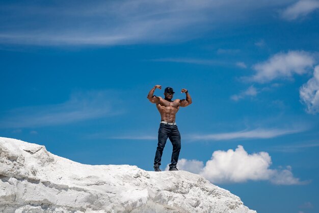 Man Conquering Majestic SnowCovered Summit A man standing on top of a snow covered mountain