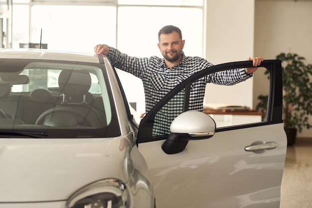 The man considers a new model range of cars and tries to choose the best for himself.