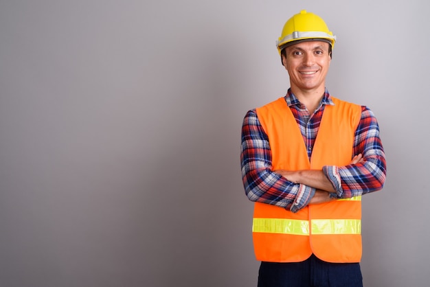 Man construction worker against gray wall