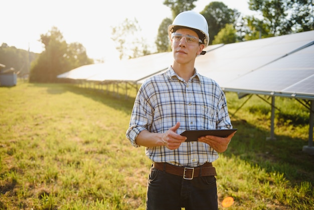 Man controleert en staat in de buurt van zonnepanelen