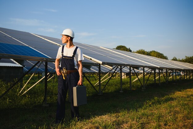 Man controleert en staat in de buurt van zonnepanelen