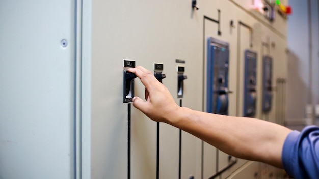 Man controls the switches on the control cabinet.