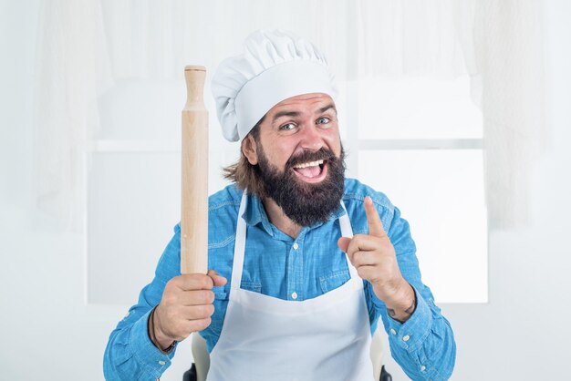 Cuoco dell'uomo che prepara il cibo nel consiglio della cucina domestica