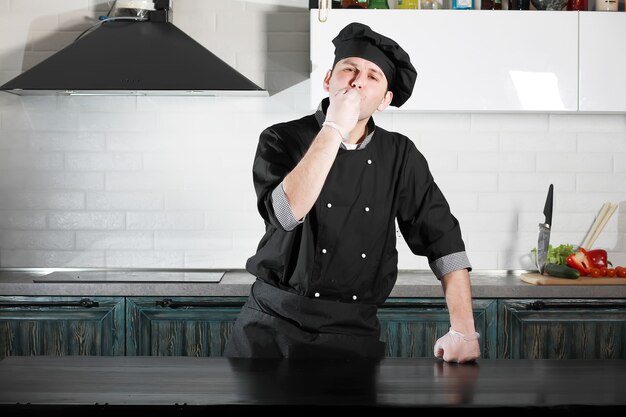 Man cook preparing food at the kitchen table of vegetables