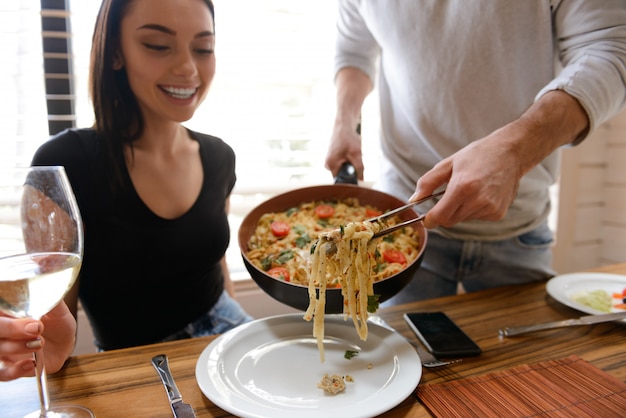 Man cooking food for girlfriend on the kitchen at home