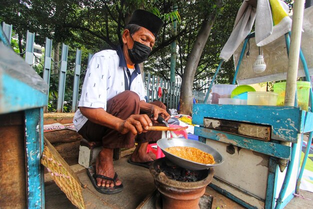 a man cooking food in a small kitchen.