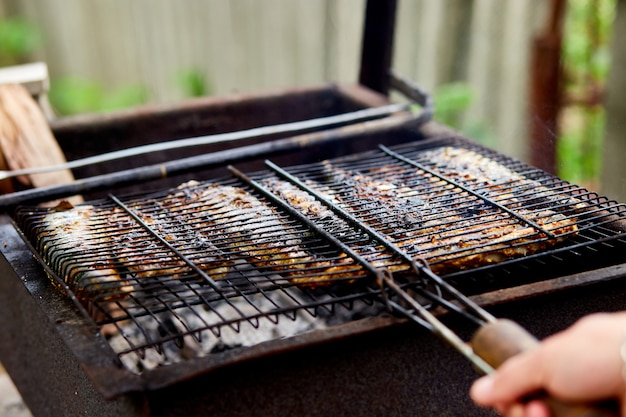 Man cooking mackerel fish on the grill