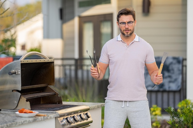 man cooking meat on barbecue in the backyard of the house handsome man preparing barbecue barbecue chef master cook preparing delicious grilled barbecue food bbq salmon grill and barbeque